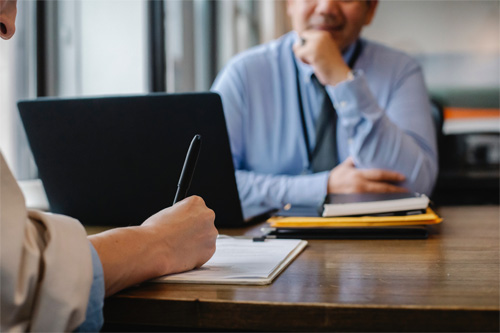 People at a desk with a laptop